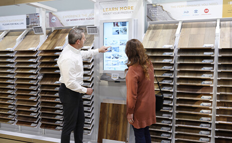 Flooring expert in a showroom showcasing hardwood and laminate flooring. Your trusted local flooring store near you for all flooring solutions.